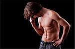 a tired and sweat  young man in topless, isolated on black. Studio shot.