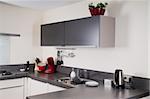 Interior of a modern grey and white kitchen with some kitchen attributes.