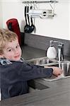 Child washing his hands before he is going cooking.