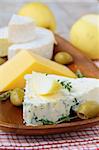 Various types of cheese on a wooden cutting board