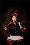 six year old boy dressed in a band uniform with drum sticks