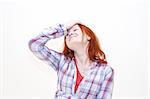 Redhead young woman holding her hand to the head with headache
