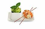 Tasty prawn in a plate with green sauce isolated on a white background.