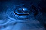 A water drop fall in water, photographed with blue filter