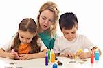 Kids busy painting with lots of colors, supervised by their mother - isolated