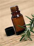 Bottle of essence oil with fresh rosemary