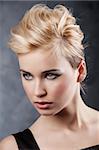 beauty portrait of young blond girl with fashion hair style and make up on dark background