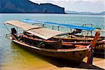 typical colorful longboats on a beach in the Phang Nga Bay