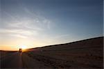 Sunset and a truck on the road in the Western Sahara in south Morocco