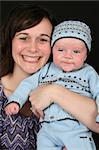 Beautiful brunette mother with her baby boy dressed in blue