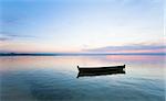 Sunset and old wooden fishing boat on summer lake bank (Svityaz, Ukraine)