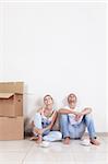 Young Couple with boxes of drinking coffee in the new apartment