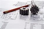 Tools on Blueprints including sprocked stacks and pencil. House plans printed on white paper.