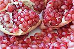 Sliced pomegranite with seeds spilling from it