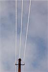 Frosted electrical wires and pole fragment on a background of the sky