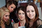 A cute young teen girl with friends in a coffee house