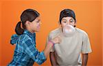 Girl touching a bubble blown by her brother with chewing gum