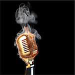 burning old golden microphone. isolated on black.