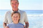 Grandfather with his grandson on the beach