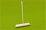 Wooden broom on green background