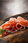 photo of delicious sliced bacon on wooden table with parsley