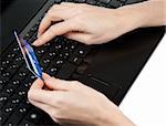 Feminine hands with bank card on keyboard of the computer