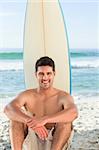 Handsome man with his surfboard at the beach