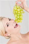 young pretty woman with white grapes