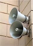 Two speakers are installed on a wall of a building