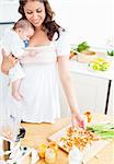 Radiant mother preparing food for her adorable baby in the kitchen at home