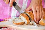 woman hands cutting bread with large knife
