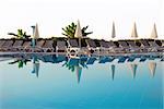 chairs row by blue swimming pool in resort in Turkey