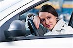 beautiful sensual woman put her head on steering wheel and looking at camera