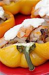 Closeup photo of stuffed pepper with shrimps, mushrooms, onion and sour cream