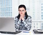 Portrait of a pretty young woman in front of a laptop computer