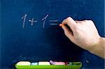 Stock photo: an image of a hand writing numbers on blackboard