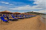 a beach filled with sun beds in Zakynthos, Greece