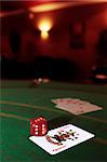 green casino table with dice on a joker and a hand of a royal flush