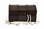 An isolated treasure chest with some loose gemstones and a pearl necklace around it.