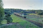 Freight train hauled by the diesel locomotive passing the forest