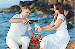 Young couple with glasses of champagne near the ocean