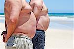 Close up of two obese fat men of the beach