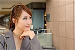 Beautiful business manager woman thinking, half length closeup portrait outside of modern buildings.