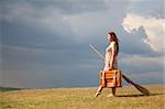 Young witch at grass field with broom