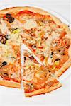 seafood pizza closeup with salmon, shrimps, tomato, pepper, olive and mozzarella cheese on a white background