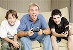 Uncle or father playing video games with two boys.