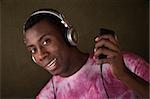 Cute African-American with headphones and pink shirt holds an mp3 player