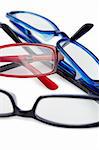 Three pairs of glasses with blue black and red frames on a white background
