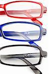 Spectacles with blue frames black frames and red frames on a white background