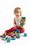 Funny boy playing with blocks, studio shot